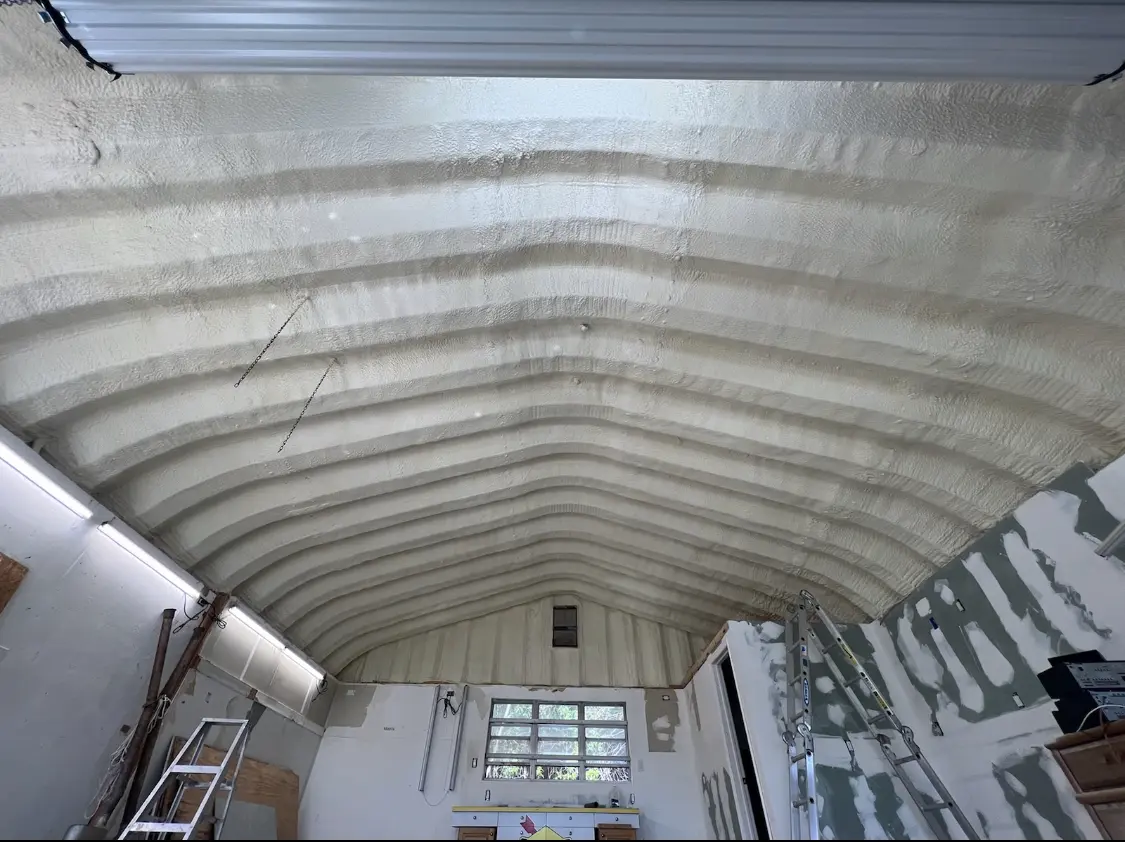 Spray polyurethane foam applied to the underside of a metal roof deck in Cambria